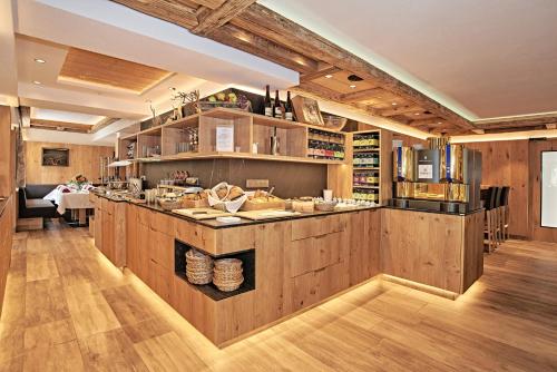 ベルヒテスガーデンにあるHotel Grünberger superiorの木製キャビネットとカウンター付きの広いキッチン