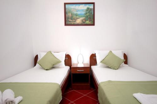 een kamer met twee bedden en een foto aan de muur bij Apartments Centar Sutomore in Sutomore