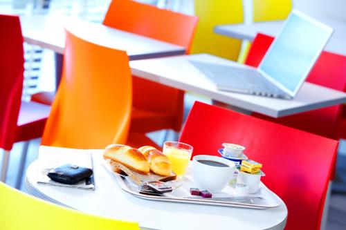 a plate of breakfast foods and drinks on a table at Premiere Classe Grenoble Sud - Gieres Universite in Gi&egrave;res