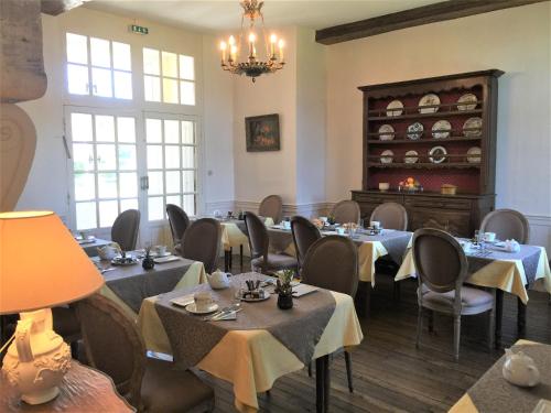a dining room with tables and chairs and a chandelier at Hôtel & SPA Château de La Côte - Brantôme in Biras