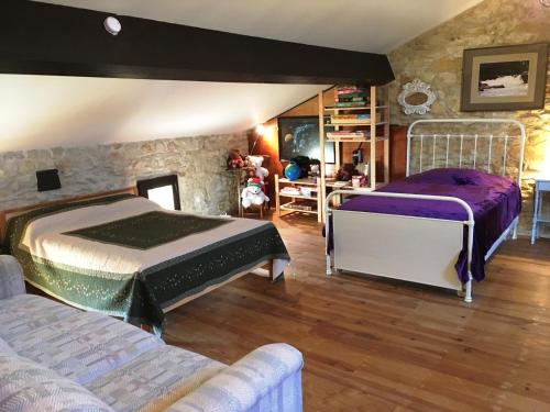 LarroqueにあるDomaine Du Colombier, Gite La Renaissanceの石壁のベッドルーム1室(ベッド2台付)