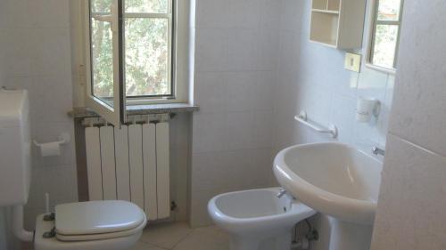 カポリーヴェリにあるAppartamenti Gli Alberiのバスルーム(トイレ、洗面台付)、窓が備わります。