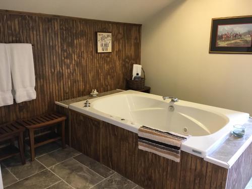 a large bath tub in a bathroom with a table at Oak Valley Inn and Suites in Geneseo