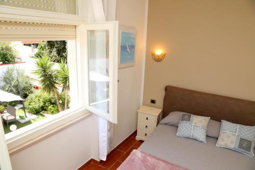 ein kleines Schlafzimmer mit einem Bett und einem Fenster in der Unterkunft Villa Piana in Castelsardo
