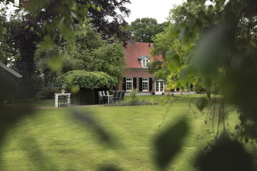 a house with a table and chairs in a yard at PicaBella - B&B en atelier in Laren