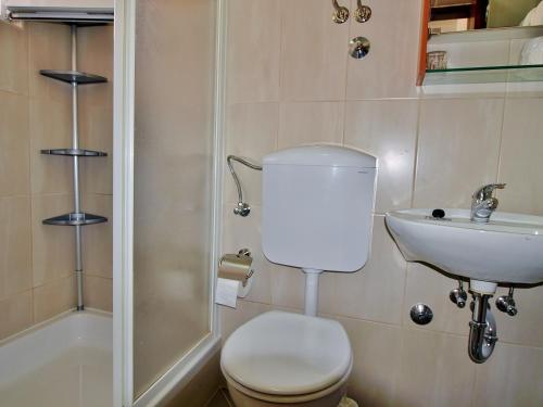 a bathroom with a toilet and a sink and a shower at Apartment Nada in Rab