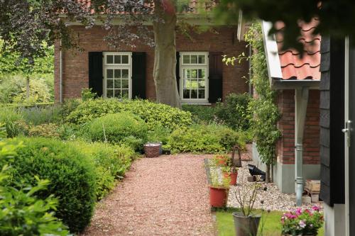 a garden in front of a brick house at PicaBella - B&B en atelier in Laren