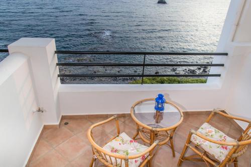 a balcony with two chairs and a glass table at Elea Mare in Elia Laconias
