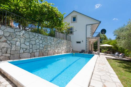 a swimming pool in front of a villa at Olive Tree Villa in Herceg-Novi