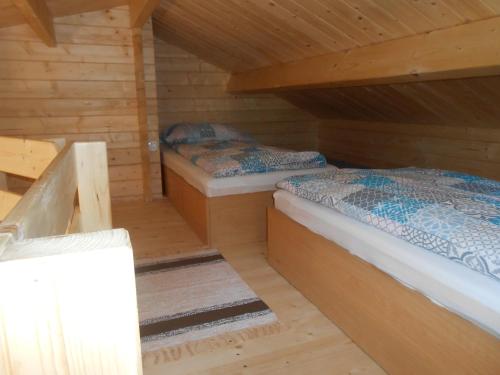 sypialnia z 2 łóżkami w drewnianym domku w obiekcie Domek pod Świerkiem w mieście Wapnica