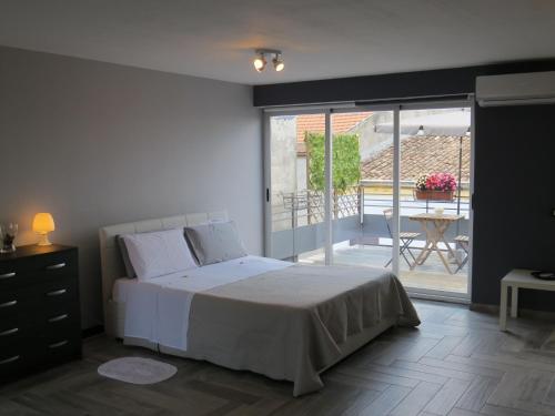 1 dormitorio con 1 cama y balcón con mesa en Sicily Etna House, en Giarre