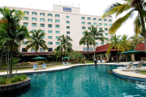 a swimming pool in front of a hotel at Aryaduta Pekanbaru in Pekanbaru