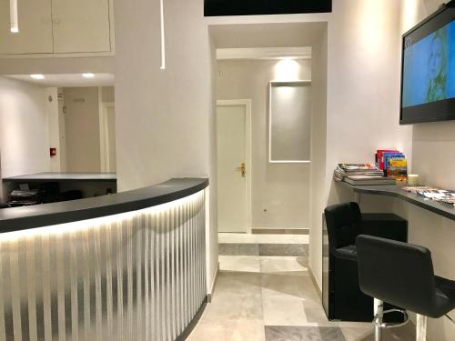 a kitchen with a refrigerator, sink and a television at Boutique Hôtel Neptune Nice in Nice