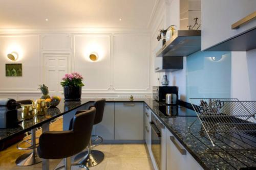 - une cuisine avec un comptoir et des chaises dans l'établissement Résidence Helianthe, à Biarritz