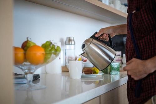 a man is making a drink in a kitchen at UP THERE design rooms in Split