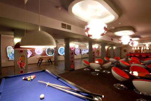 a billiard room with a pool table and chairs at Hotel Styl 70 in Pszczyna