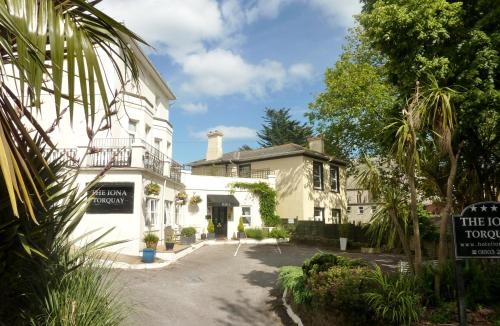 a white house with a sign in front of it at The Iona in Torquay