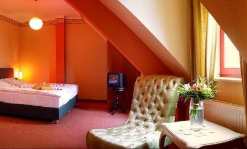 a bedroom with a bed and a chair and a table at Zur Alten Schmiede in Naumburg