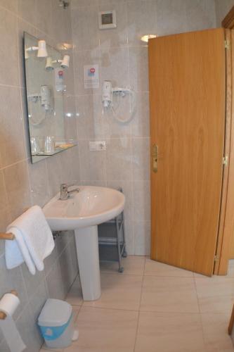 a bathroom with a sink and a mirror at Hostal Casa Maria in Portonovo