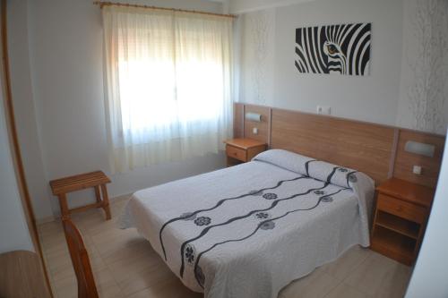 sypialnia z dużym łóżkiem i oknem w obiekcie Hostal Casa Maria w mieście Portonovo
