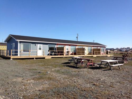 a house with picnic tables in front of it at Oceanside Cabins in Bonavista