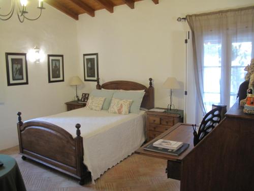 a bedroom with a bed and a table and a window at Casa dos Cactos in Vila Nova de Milfontes