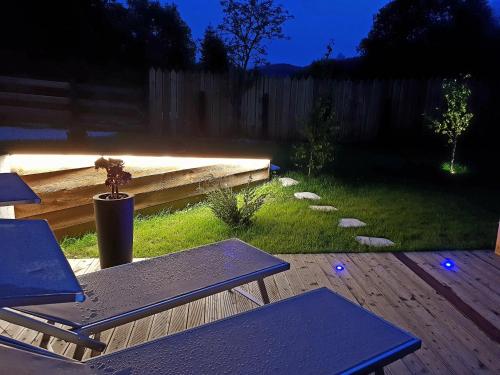a backyard with two picnic tables and a fence at Aqua Apartments Spa Housemuhlbach in Sappada