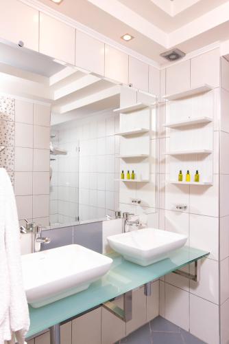 a bathroom with two sinks and a mirror at Mythodea Apartments in Limenas