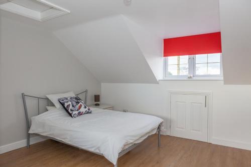 a bedroom with a bed and a red window at Park View Studio - Lydiard Millicent Swindon Wiltshire in Swindon