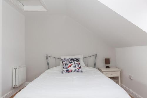 ein Schlafzimmer mit einem weißen Bett und einem Kissen darauf in der Unterkunft Park View Studio - Lydiard Millicent Swindon Wiltshire in Swindon