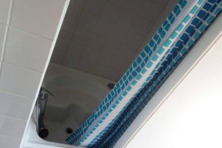 La salle de bains est pourvue d'une baignoire avec un miroir. dans l'établissement The coolest baby penthouse in Oostende, à Ostende