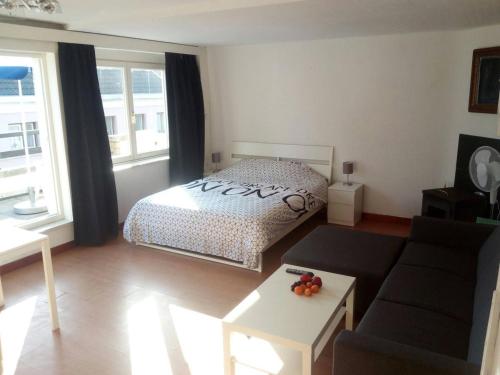 a living room with a bed and a couch at The coolest baby penthouse in Oostende in Ostend