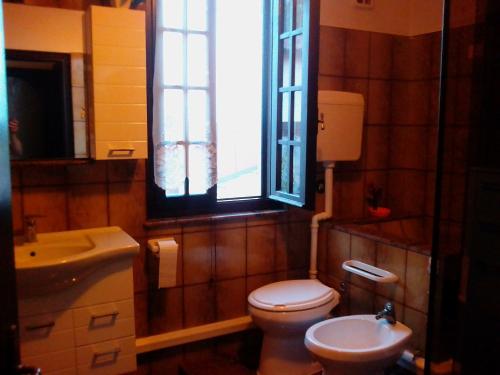 baño con aseo y lavabo y ventana en Casa Bondone en Villanuova sul clisi