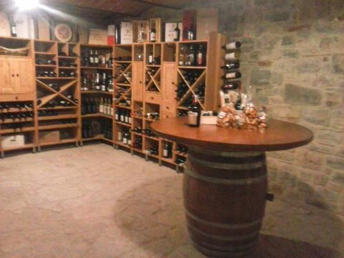 una bodega con una mesa de barril y estanterías de botellas de vino en Agriturismo Valiana, en Montegabbione
