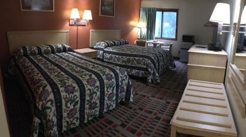 a hotel room with two beds and a television at Anderson Chesterfield Travel Inn in Daleville