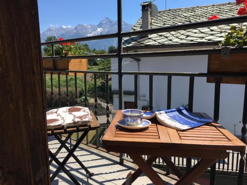 d'une table sur un balcon avec vue sur les montagnes. dans l'établissement Coeur de montagne, à Gignod