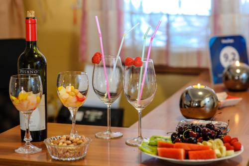a table with three wine glasses and a plate of fruit at Voulias Αpartments in Kinion