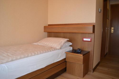 a small bedroom with a bed and a night stand at SunLake Hotel in Riva del Garda