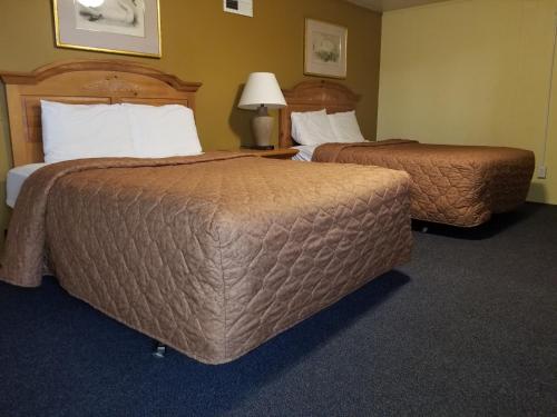 a hotel room with two beds and a lamp at Rodeway Inn La Crosse in La Crosse