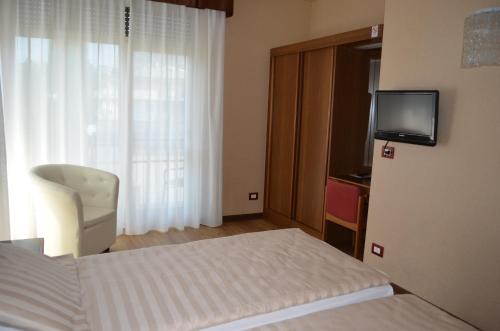 a hotel room with a bed and a television at SunLake Hotel in Riva del Garda