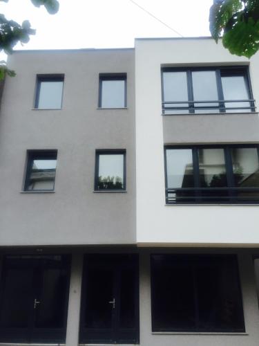a white building with black windows at Apartment Adi in Travnik