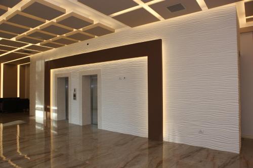 a large white wall in a room with a ceiling at Hotel GRINT in Golem