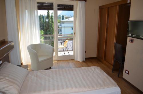 a bedroom with a bed and a view of a balcony at SunLake Hotel in Riva del Garda