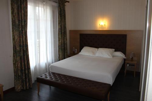 En eller flere senger på et rom på Hôtel Etang des Reynats