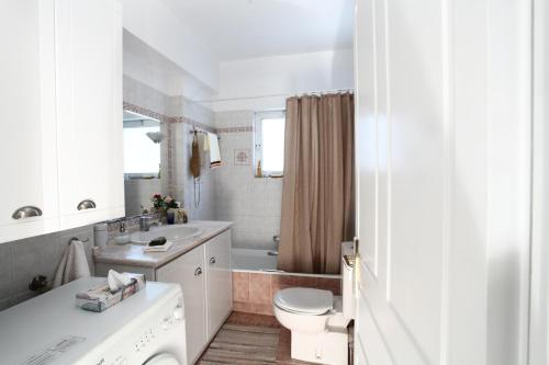 a white bathroom with a toilet and a sink at Unique Flat with Sea View at Edem Beach - A Seafront Property by Athenian Homes in Athens