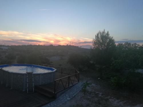a hot tub on a deck with the sunset in the background at Aura Solis B&B in Leuca