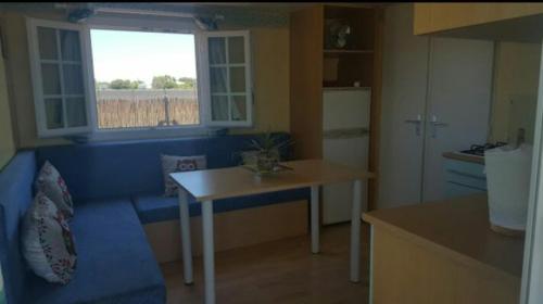 エル・パルマルにあるCasa Prefabricadaのキッチン(青いソファ、テーブル、窓付)