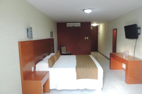 a hotel room with a bed and a tv at Hotel Central in Veracruz