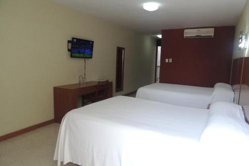 a hotel room with two beds and a tv at Hotel Central in Veracruz