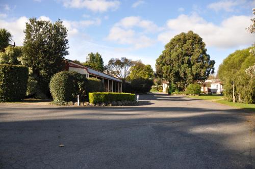a street in a residential neighborhood with trees and a building at Miner's Retreat Motel in Ballarat